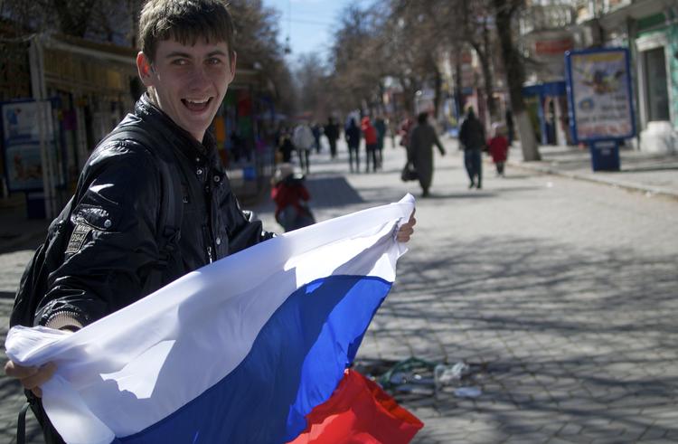 Russisk. En teenager løber gennem gaderne i Simferopol på Krim-halvøen i dag, efter at et flertal i går stemte for, at Krim skal slutte sig til Rusland. I dag har Ukraine hjemkaldt sin ambassadør i Rusland. 