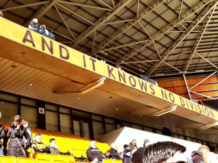 slogan. Man kan sige, at det nye slogan på 'Stan Cullis-tribunen' på Molineux i Wolverhampton passer meget godt med holdets seneste skæbne. Men 'this is our love - and it knows no division' afspejler åbenbart også opbakningen fra klubbens fans. 