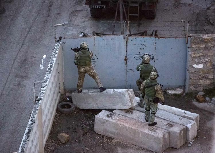 Krim. Det, der menes at være prorussiske militser, afsøger et område tæt ved en ukrainsk militærbase i Simferopol i går. De svært bevæbnede soldater stormede en ukrainsk base. En ukrainsk soldat og en prorussisk militsmand blev dræbt. Men der skal mere til at udløse en decideret krig, siger flere danske militæreksperter. 