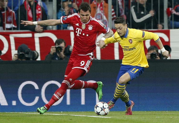 Offer. Mesut Özil (th) i nærkamp med Bayerns Mario Mandzukic. 