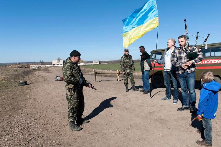 Støtte. De seneste måneders begivenheder har gjort Denys Radenko til en glødende nationalist. Her står han med det ukrainske flag ved den militærbase, han og hans venner forsyner med mad og tøj. 