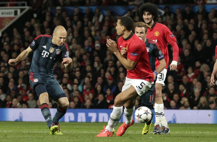 håndbold. Bayerns Arjen Robben (tv) forsøger sig med et skud mod den røde mur af spillere omkring Manchester Uniteds straffesparksfelt. 