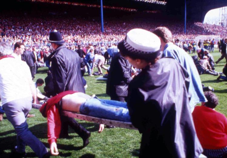 FODBOLDTRAGEDIE. En kvæstet tilskuer bæres ud af Hillsborough Stadion i Sheffield efter katastrofen 15. april 1989. 