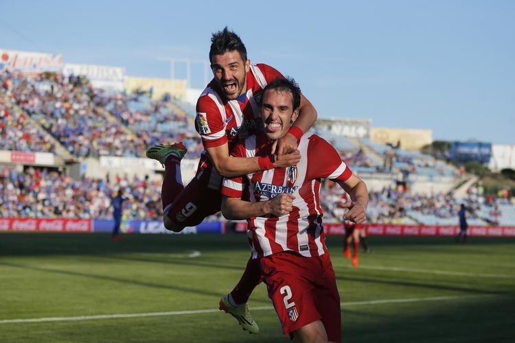 Glæde. David Villa springer akrobatisk op på holdkammerat Diego Godin for at juble over 1-0-scoringen. 