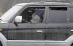 Militært. En prorussisk militant kigger ud af sin ødelagt bil i den østukrainske by Slovjansk. 