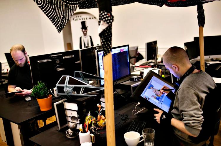 kreativitet. Casper Høg (th.) er i sin helt egen verden, når han tegner direkte på sin skærm. Han har indrammet sin plads med et lille halvtag, fordi lyset fra loftet går i skærmen. I baggrunden ses Uffe Flarup. 