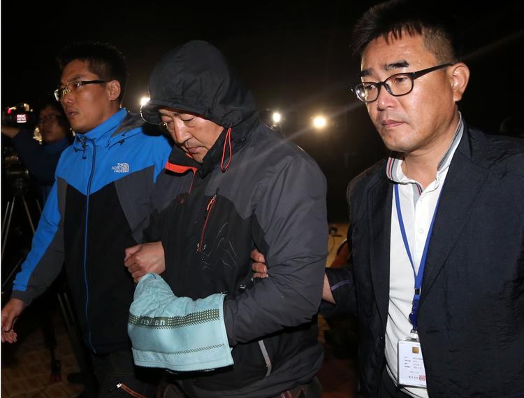 Skibsforlis. »Jeg beklager over for befolkningen i Sydkorea, at jeg har forårsaget uro. Jeg bøjer hovedet og undskylder over for ofrenes familier«, siger kaptajn Lee Joon-Seok (i midten), der er anholdt efter skibsforliset ved Sydkoreas kyst i onsdags. 