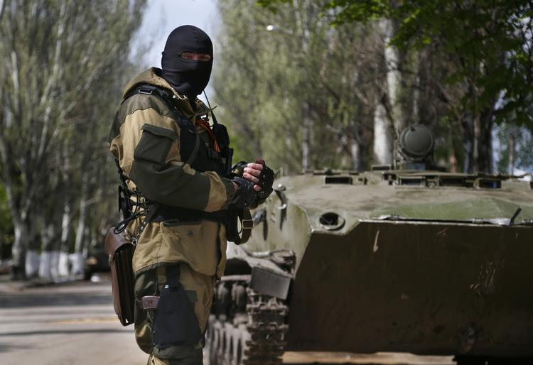 MILITANT. Russisksindet militsmedlem foran pansret bæltekøretøj i Slavjansk. 