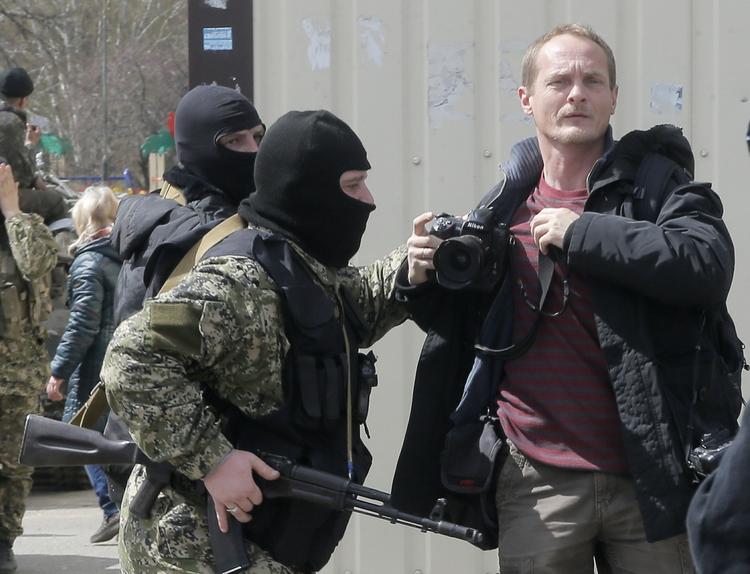 OVERFALD. De militante russisksindede har ved flere lejligheder været særdeles aggressive over for journalister, både op til den russiske annektering af Krim og senere under aktioner i det østlige Krim. Her er det en fotograf, der chikaneres i Slavjansk. Han arbejdede for den russiske avis Kommersant. 