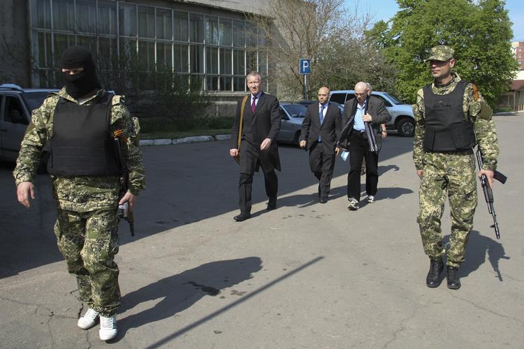 GIDSELTAGNING. OSCE-udsendinge eskorteres af væbnede medlemmer af russermilitsen i Slavjansk op vej til forhandlinger om løsladelse af fangerne. 