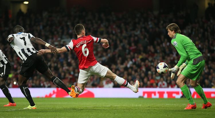 3-0. Arsenals Koscielny lavede det første mål efter 25 minutter, hvor han akkurat fik en lang tå på bolden, da Santi Cazorla sendte et frispark ind foran Newcastles målmand Tim Krul. 