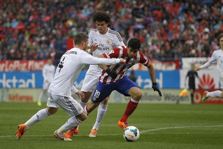Outsider. Diego Costa (i midten) blev matchvinder for Atletico i sæsonens første kamp mod Real Madrids Sergio Ramos og Pepe. 