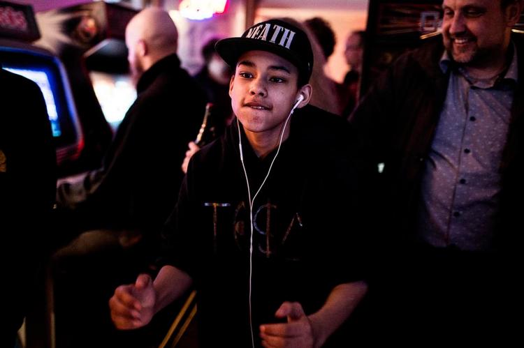 Tidslomme. Det er en lille fast gruppe af mænd og kvinder i alle aldre, der holder til omkring arkadespillene hos Chassis. Yngstemanden er stortalentet Nicklas (med sort kasket og øretelefoner) på 14. Foto: Ditte Valente 