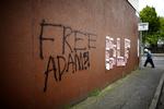 'Sæt Adams fri', lyder et slagord malet på en mur i Belfast. 