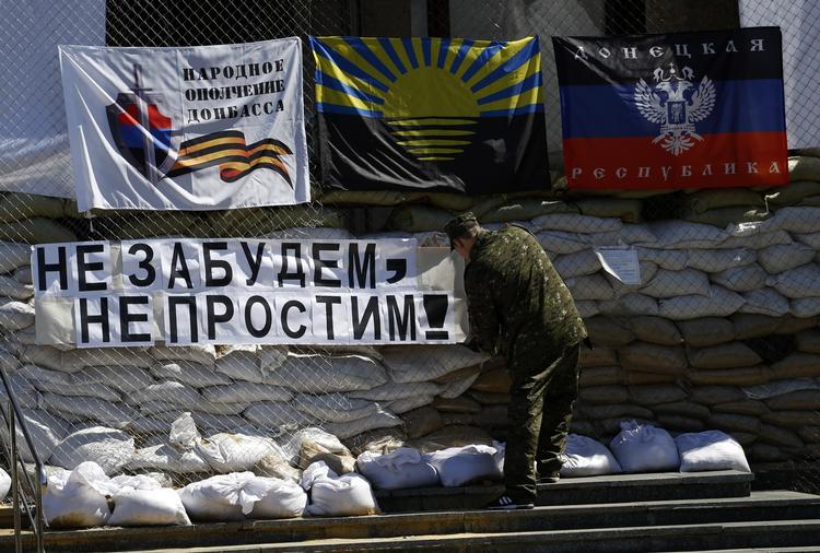 Modstand. En pro-russisk militant hejser et banner med teksten 'Glem ikke - tilgiv ikke' i centrum af byen Slavjansk, hvor der skal være afstemning om selvstændighed. 