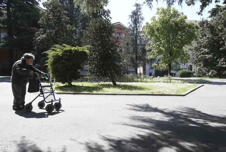 Legeonkel. En ældre kvinde triller afsted foran det plejehjem, hvor Berlusconi i det næste års tid skal spille spil og synge sange. 