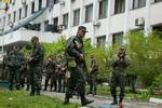 Uro. Ukrainske soldater foran en offentlig bygning i Mariupol i går. I dag har den ukrainske by været ramme om hårde kampe., der har medørt flere dræbte. 