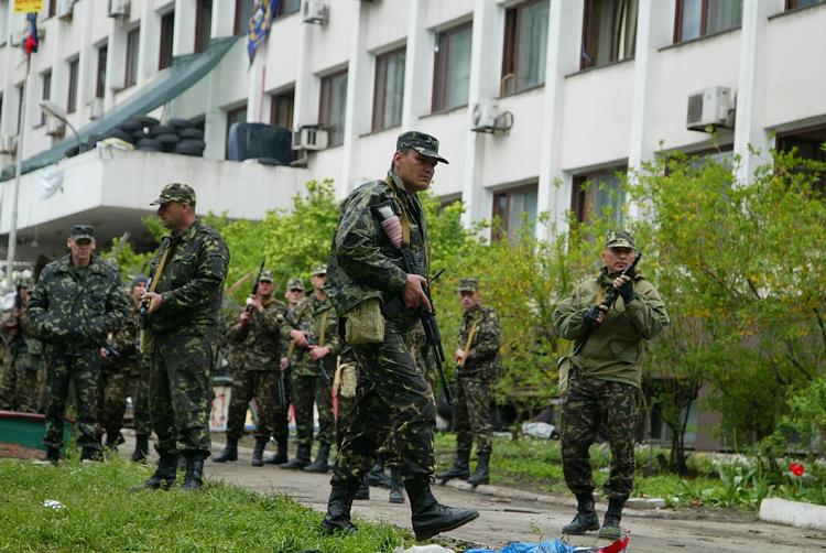 Uro. Ukrainske soldater foran en offentlig bygning i Mariupol i går. I dag har den ukrainske by været ramme om hårde kampe., der har medørt flere dræbte. 