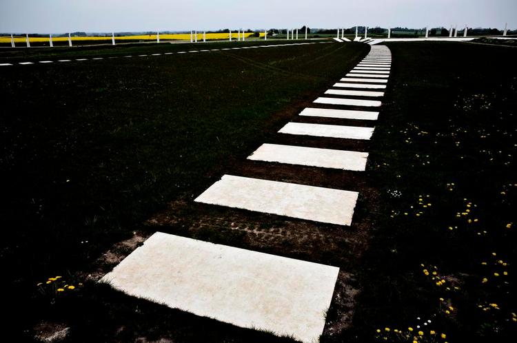 Betongrafik. Den oprindelig 360 meter lange skibssætning er optegnet af store betonfliser i engen. Foto: Joachim Adrian. 