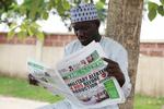 kidnapninger. En lokal læser dagens avis, hvor forsiden omhandler kidnapningen af mere end 200 nigerianske skolepiger. 