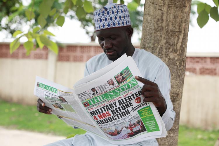 kidnapninger. En lokal læser dagens avis, hvor forsiden omhandler kidnapningen af mere end 200 nigerianske skolepiger. 
