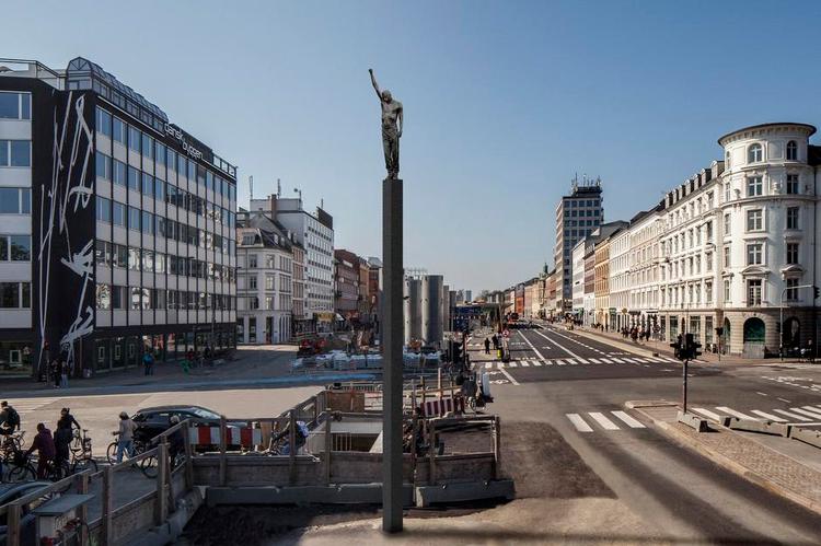 Medborger. Carstensens skulptur er i naturlig størrelse, så man kan genkende sin egen krop i den. Men samtidig er skulpturen hævet unaturligt højt op på sin smalle, otte meter høje søjle, hvor den er helt uden for rækkevidde 