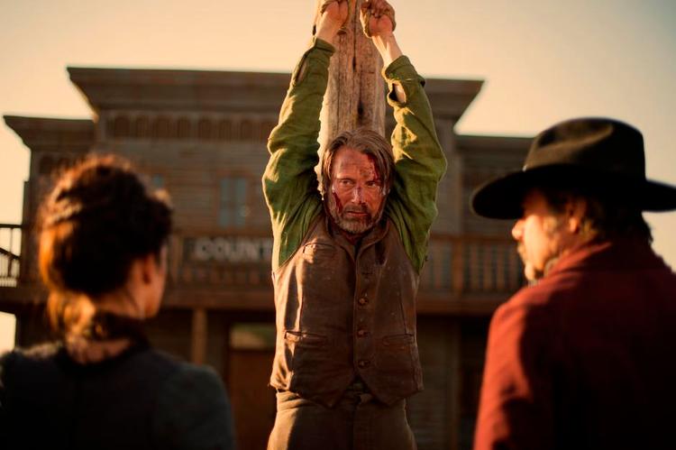 hårdkogt. Western-traditionen tro kan Mads Mikkelsen tage de tæv, der falder på ham. Kujonerne skal findes i den lille by. 