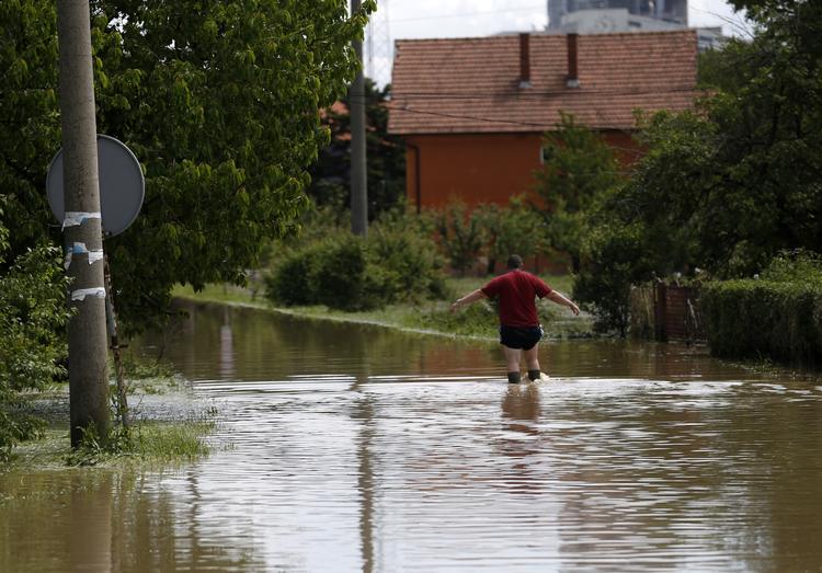 Overvsvømmet. Nogle steder stiger vandstanden stadig - andre steder trækker vandet sig tilbage. Manden her går i en forstad til Beograd, hvor vandstanden i floderne stadig stiger. 