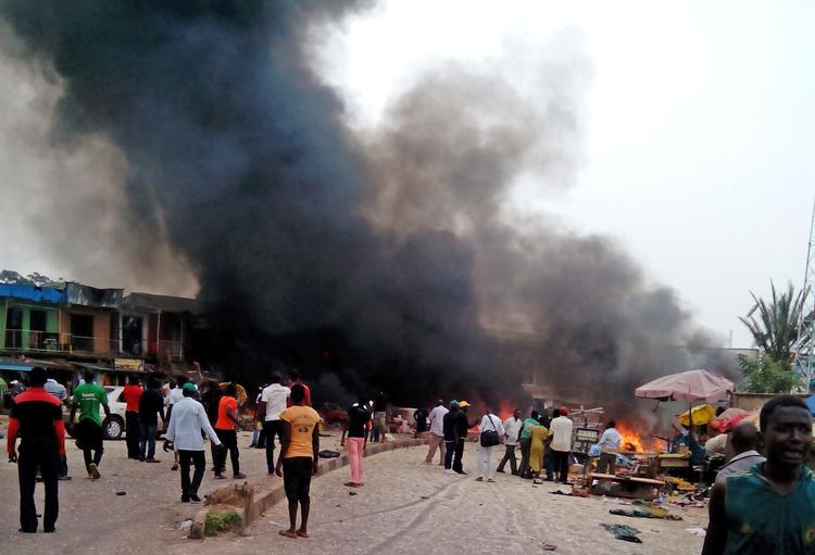 Vold. Røg stiger fra en brændende bil ved busstationen i byen Jos i Nigeria. To bilbomber sprængte i går ved et det overfyldte marked ved busholdepladsen. 
