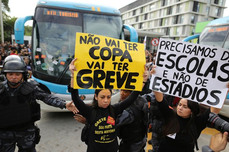 VM-modstand. Demonstranter standsede den brasilianske landsholdsbus på vej til trænings-basen, mens der blev holdt bannere op med påskriften: 'Der bliver ikke en slutrunde. Der bliver strejker' og 'Vi behøver skoler - ikke stadions'. 