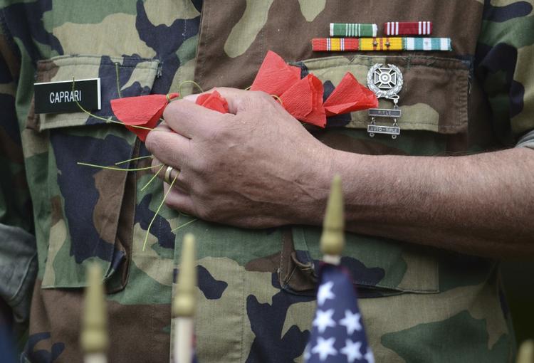 Larry Caprari er veteran fra Vietnamkrigen. Han knuger hånden om en bunke valmueblade, som skal bruges til at ære faldne amerikanske soldater, der mindes under Memorial Day. 