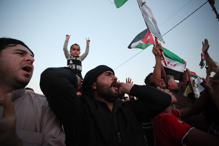 Syriske oprørere i Amman råber slagsange i protest mod Assad, mens de fejrer den jordanske regerings beslutning om, at udvise den syriske ambassadør Bahjat Suleiman fra Jordan. 