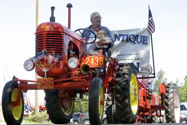 Fred Clayton holder sit otte måneder gamle oldebarn, mens de kører på en antik traktor under fejringen af Memorial Day i Toms River, New Jersey. 