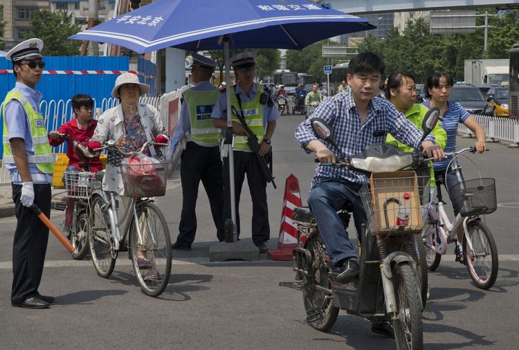 årsdag. En bevæbnet politimand holder vagt ved et sikkerhedstjek i Beijing i dag. Hovedstaden oversvømmes i dag af politifolk, hvis opgave er at sikre, at 25-årsdagen for massakren på Den Himmelske Freds Plads ikke bliver markeret på nogen måde. 
