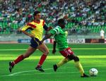 ældst. Roger Milla fra Cameroun (th) scorer sit første af to mål i kampen mod Rumænien ved VM i 1990. 