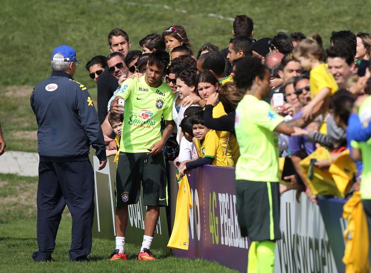 fan-pleje. Neymar (nummer to fra venstre) laver en 'selfie' med en af de mange fans, der møder frem ved den brasilianske træning før VM. 