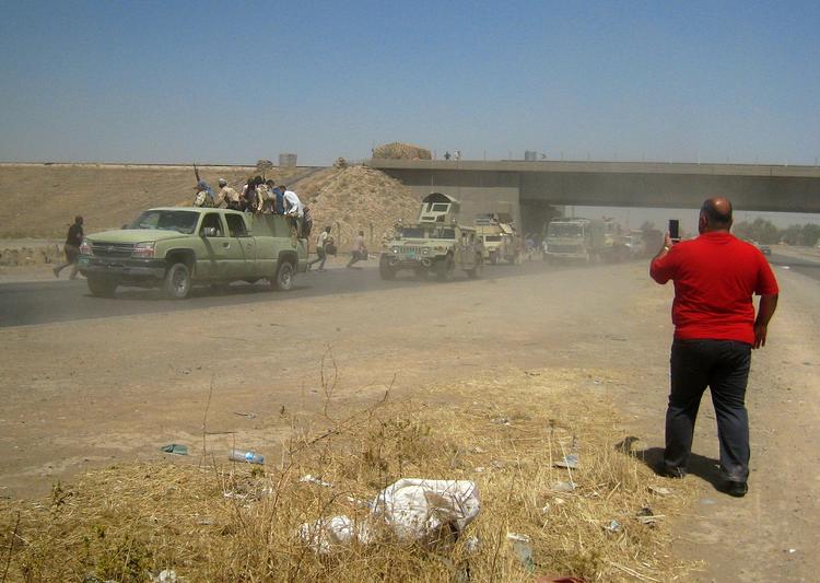 TILBAGETRÆKNING. Civil fotograferer en kolonne af politifolk og soldater på flugt fra Mosul. 