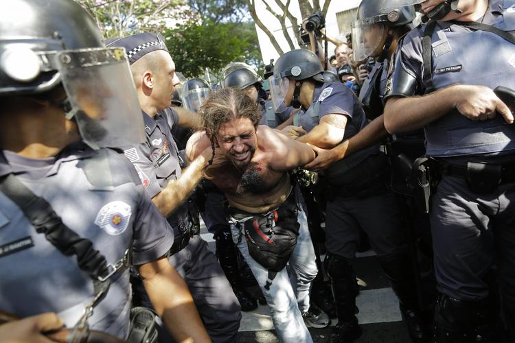 optøjer. Politiet i Sao Paulo arresterer en demonstrant, som er blevet pacificeret med tåregas. 