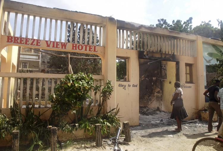 TERRORANGREB. Kvinde ser på ruinen af Breeze View-hotellet, en af de bygninger i Mpeketoni, som blev sat i brand under stormløbet mod den kenyanske by. 