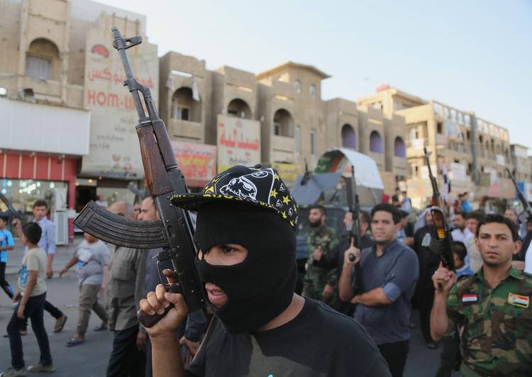 uro. Shiiter i bagdads Shula-kvarter løfter deres våben og råber slogans mod Isis-bevægelsen. Sunni-militante har de seneste dage indtaget en stribe større byer i det nordlige Irak. 