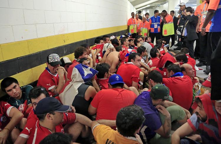uro. Chilenske fans omringet af sikkerhedspersonale efter de brød ind i pressecentret Maracana stadion en time før kampen mellem Chile og Spanien gik i gang. Omkring 200 fans forsøgte at skaffe sig adgang til stadion via pressens arbejdsområde. 