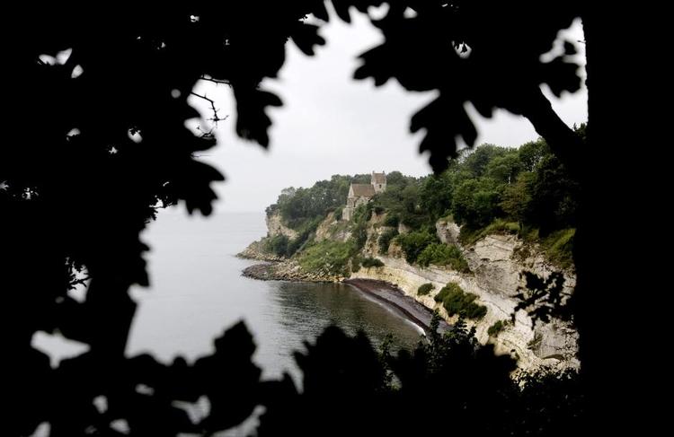 DØDSMÆRKE. Den sorte aftegning i Stevns Klint er et lag fra den mørke tid efter det asteroidenedslag, der blandt andet udryddede dinosaurerne. Striben kan ses fra stranden neden for klinten; den er de fleste steder cirka i øjenhøjde med en voksen. Foto: Peter Hove Olesen og Martin Lehmann 