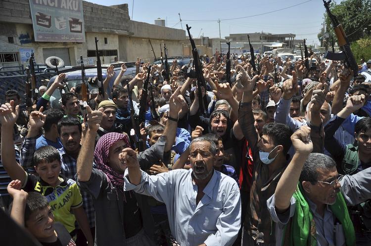 oprør. Sørgende råber slogans mod den militante, islamistiske oprørsgruppe Isis i forbindelse med en begravelse af 15 personer i byen Kirkuk i det nordlige Irak. 