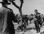 Ikonisk. Wallach er ved at grave skatten op i 'Den gode, den ond og den grusomme' mens Lee Van Cleef (tv) truer med pistol og Clint Eastwood ryger cigar på en cool måde. 
