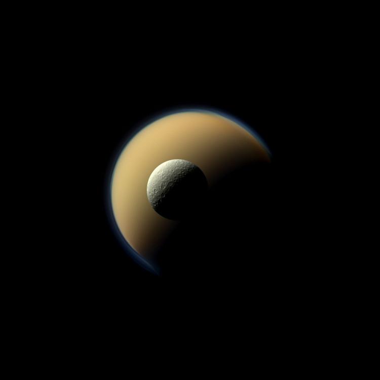 Naturtro. Saturns største måne, Titan, og den næststørste, Rhea. Billedet er taget af rumfartøjet Cassini og viser månerne i deres virkelig farver. Et rødt, et grønt og et blåt filter er blevet brugt og lagt sammen for at frembringe en ægte farve. 