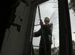 En mand i Slavjansk i Donetsk på vej op for at reparere sit tag og sine ruder efter ukrainske styrkers bombardement af prorussiske separatister i Øst-ukraine. 