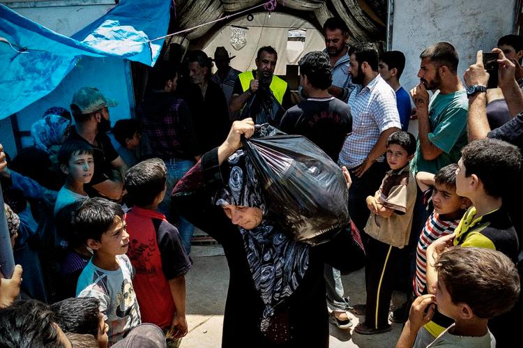 Hjælp. Organisationen Viomis driver flygtningelejren An Nawa'eer i Syrien. Her deler formand Khalid Alsubeihi (i gul vest) nødrationer af mad ud til lejrens godt 2.200 beboere. 