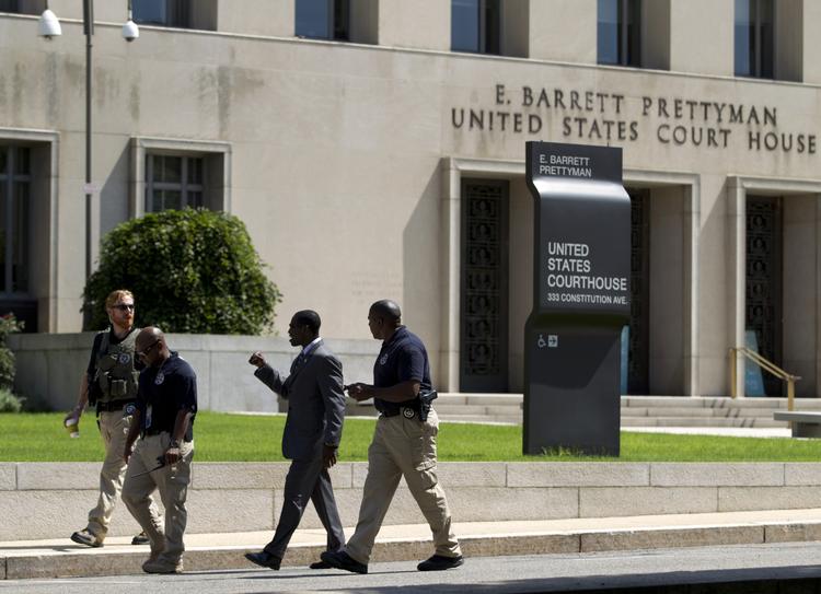 Politifolk bevogter retsbygningen i Washington, hvor Ahmed Abu Khattala skal forsvare sig mod anklager om drab på en amerikansk ambassadør i Libyen. 