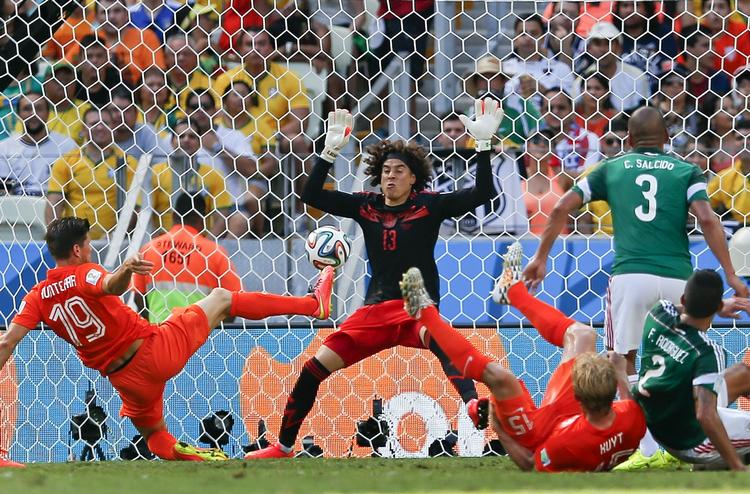 REFLEKS. Selv om Klaas-Jan Huntelaar var dømt offside, fik Guillermo Ochoa også forhindret denne afslutning fra at gå i mål - men til sidst måtte den mexicanske sprællemand give fortabt. 
