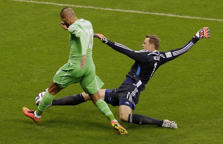 tackling. Manuel Neuer (th) måtte næsten helt ud til sidelinjen for at standse Algeriets  Islam Slimani. 